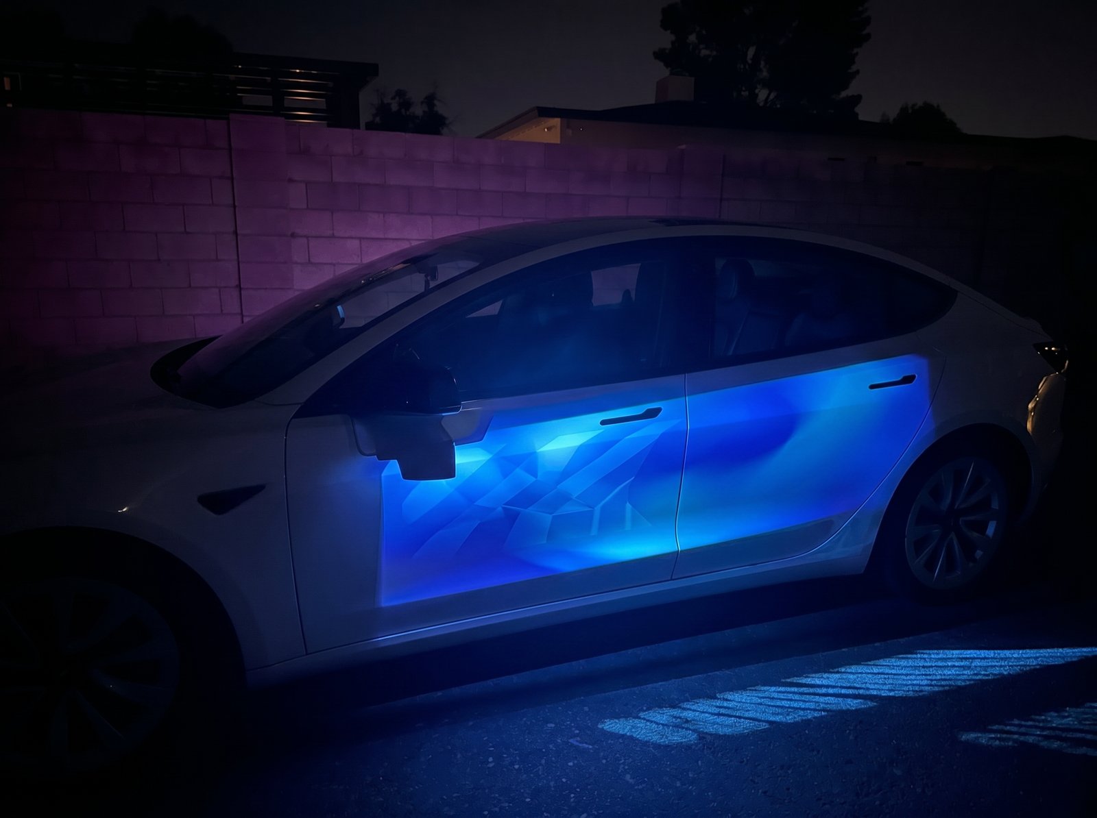 A SafeArbor fleet vehicle at night in Phoenix with the Adway projector running